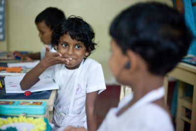 Two children use sign language in a classroom