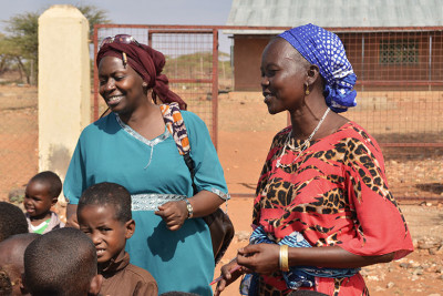 Kenyan teachers singing a traditional song with a group of children