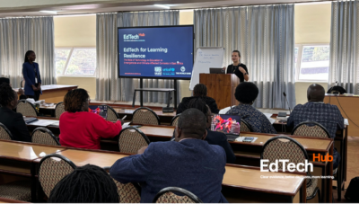 People in a room watch a speaker present about EdTech